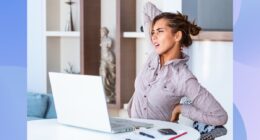 woman stretching and experiencing back pain while seated at her desk