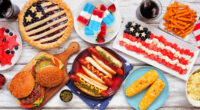 Fourth of July, patriotic, American themed food. Overhead view table scene on a white wood background.