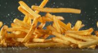 Flying French Fries Falling on Table. Fast Food Concept with Flying Food.