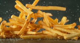 Flying French Fries Falling on Table. Fast Food Concept with Flying Food.