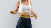 woman measuring her waistline, concept of tips for women to achieve lasting weight loss after 40