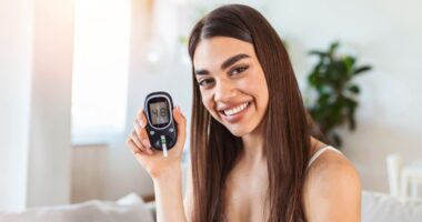 Blood sugar testing at home. Checking Blood Sugar Level At Home. Diabetic Checking Blood Sugar Levels. Woman checking blood sugar level by glucometer and test stripe at home