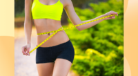 fit woman close-up measuring waistline outside