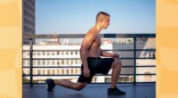 fit man doing walking lunges on rooftop workout space