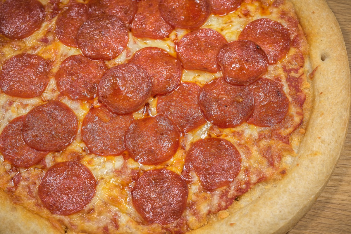 Pepperoni Pizza Up Close Studio Shot against a wooden background