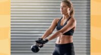 fit, focused woman doing kettlebell swing exercise