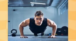 man doing pushups in a dark gym