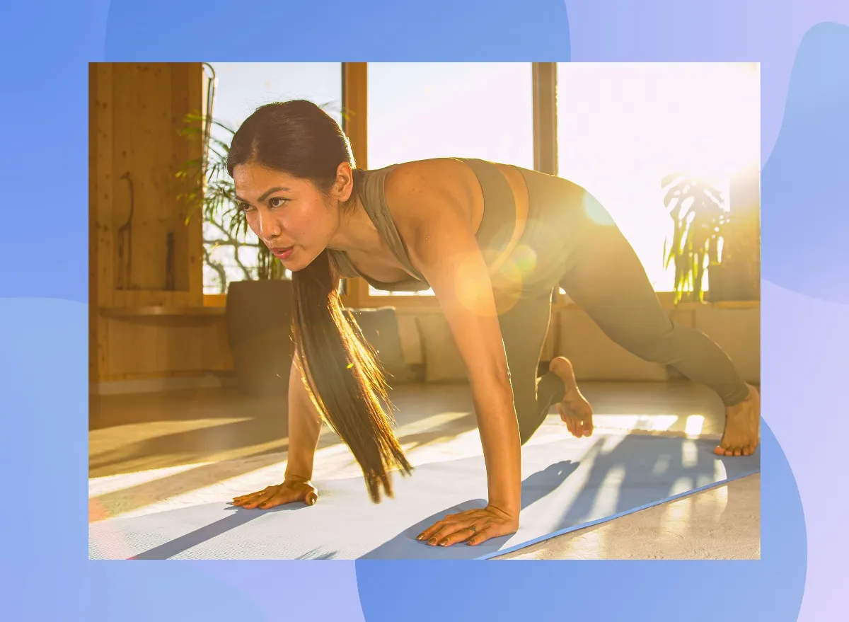 fit, focused woman doing mountain climber exercise at home in bright living space