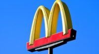 Phoenix, Arizona - Dec. 01 2023: A McDonalds famous golden arches sign at one of their restaurant locations along Interstate 10 south of Phoenix. (sign has logo with no words against bright blue sky)