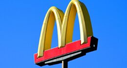 Phoenix, Arizona - Dec. 01 2023: A McDonalds famous golden arches sign at one of their restaurant locations along Interstate 10 south of Phoenix. (sign has logo with no words against bright blue sky)