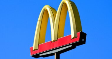 Phoenix, Arizona - Dec. 01 2023: A McDonalds famous golden arches sign at one of their restaurant locations along Interstate 10 south of Phoenix. (sign has logo with no words against bright blue sky)