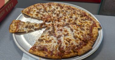 Honolulu - August 15, 2024: A freshly baked pizza sits on a metal tray, with a few slices taken, ready to be enjoyed at a lively Chuck E. Cheese venue in Hawaii.