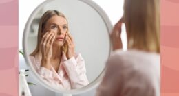 middle-aged woman looking at face in mirror