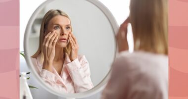 middle-aged woman looking at face in mirror