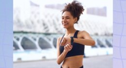 happy woman checking her fitness tracker while outdoors on a walk