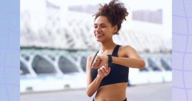 happy woman checking her fitness tracker while outdoors on a walk