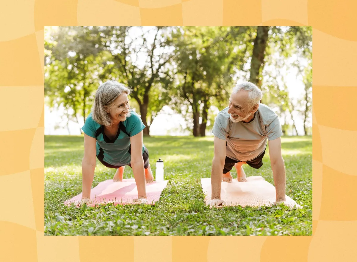 mature, happy couple doing high planks exercise in park on yoga mats on bright, sunny summer day